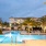 a swimming pool in front of a building with palm trees